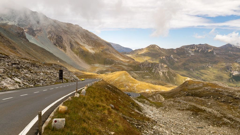 An empty alpine ridge at first light, with a single footpath winding toward a distant saddle.